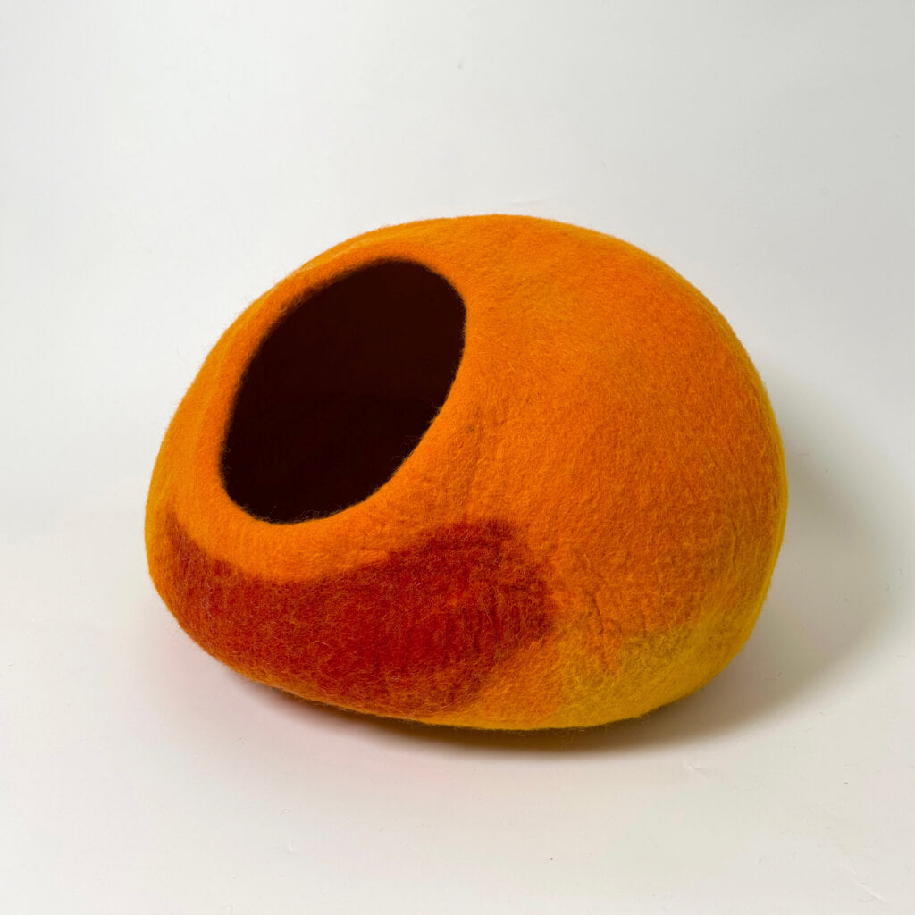 Cozy Felt Cat Cave in vibrant sunset tones of orange and red, shown empty from the side view. Modern cat hideaway crafted from eco-friendly wool felt.