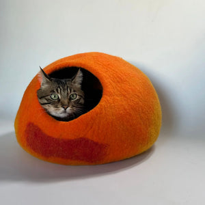 Close-up of a tabby cat peeking out from the Cozy Felt Cat Cave, featuring a soft wool felt construction and gradient sunset color design for modern home decor.