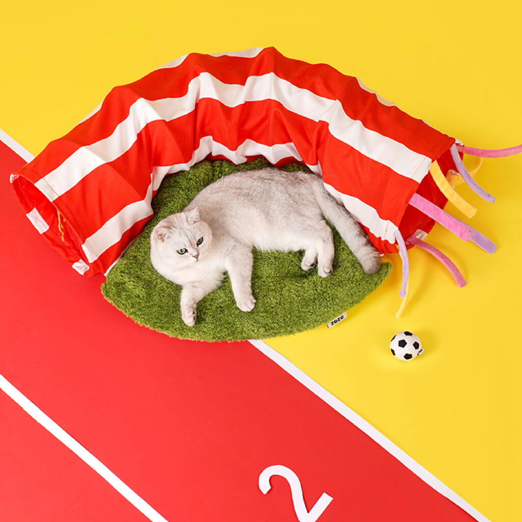 ZEZE Football Field Cat Tunnel Toy set up for playful interaction with a dangling toy and colorful tail ribbons.