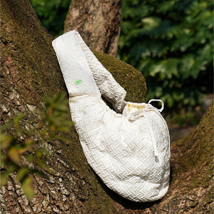 Crossbody Pet Travel Bag hanging on a tree branch, showcasing its durable and versatile design.