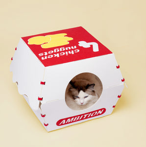 Cat comfortably resting inside the Nugget Box Cat Hideaway, with a bright nugget box theme.