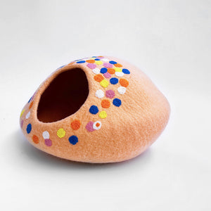 Side view of the peach-pink felt cat cave, decorated with colorful polka dots, providing a stylish hideaway for cats.