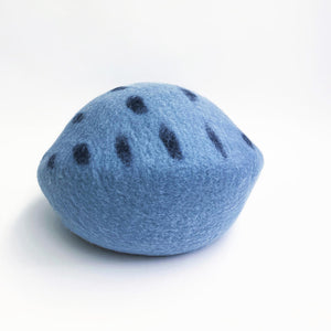 Side view of the Ocean Blue felt cat cave with playful dark blue dots.