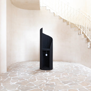 Time Travel Cat Tower - Black in a modern interior setting with stone floor and staircase.