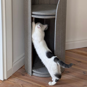 Cat enjoying a cozy perch in the Time Travel Cat Tower - Light Grey, blending seamlessly into home décor.