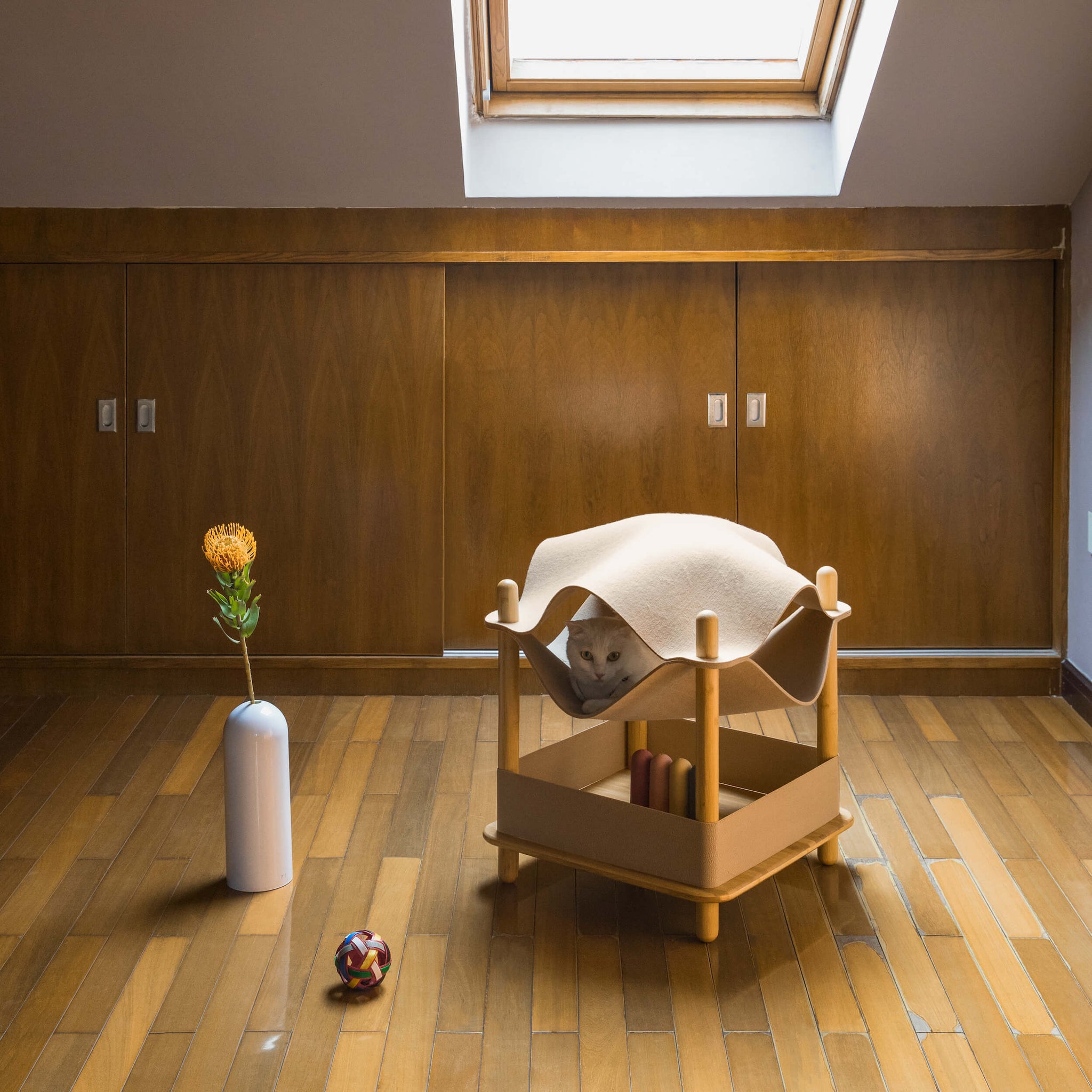 Smelling felt cat bed with bamboo side table, featuring a cat lounging inside the felt bed.