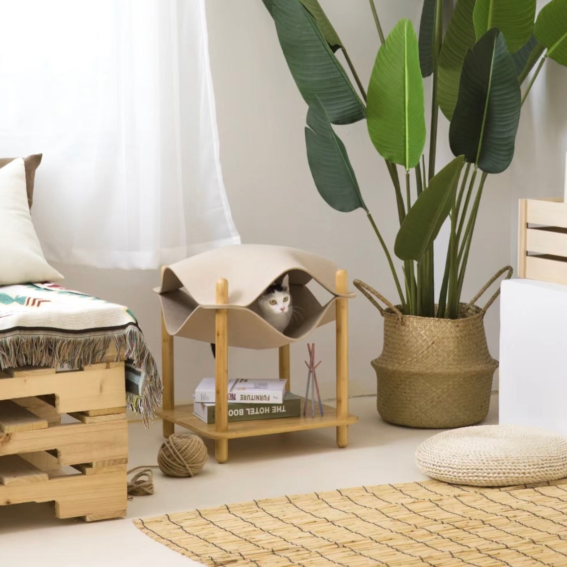 Side view of bamboo cat side table with soft felt cat bed and storage shelf underneath.