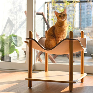 Minimalist bamboo side table with a cozy cat bed in felt, featuring a cat resting on top.