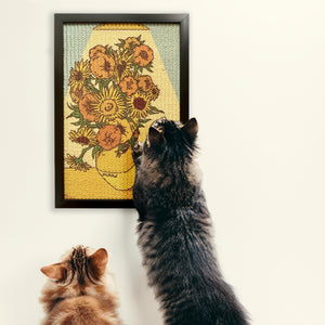 Two cats admiring a Van Gogh-inspired sunflower painting scratcher mounted on the wall.