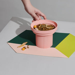 Placing a pink food bowl on the Chroma Party Pet Dining Mat - #Power Green.